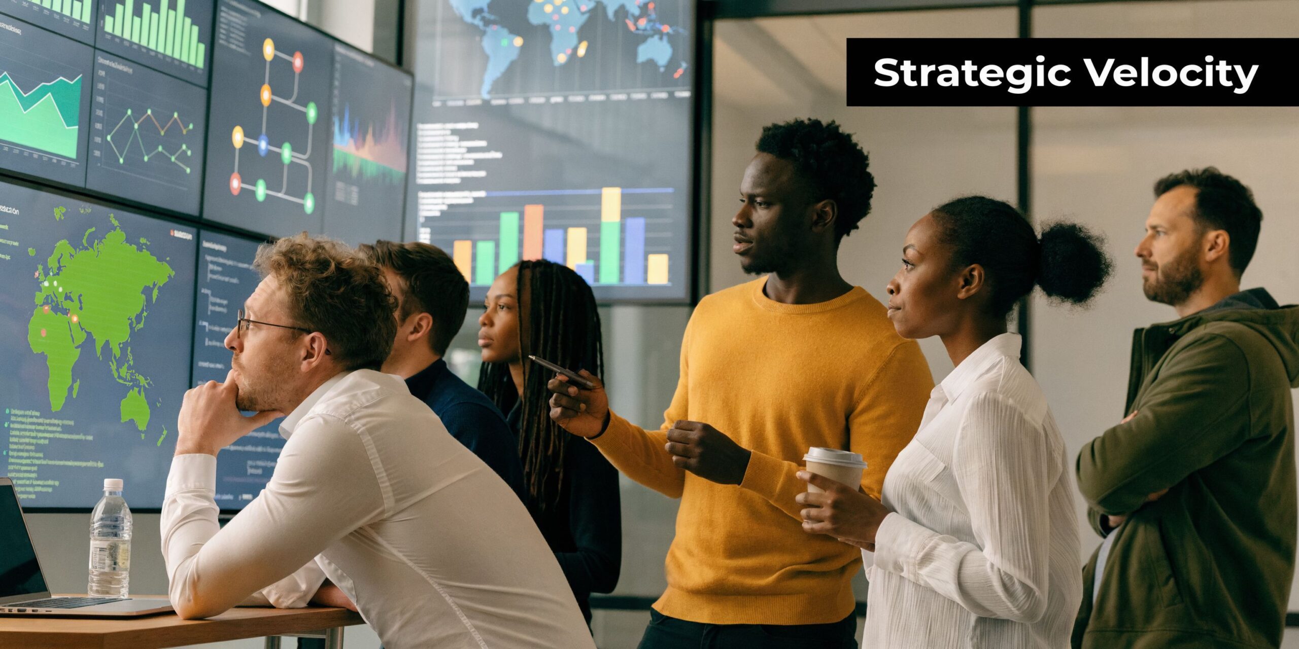 A professional team of data analysts collaborates while reviewing complex business metrics on large digital display monitors.