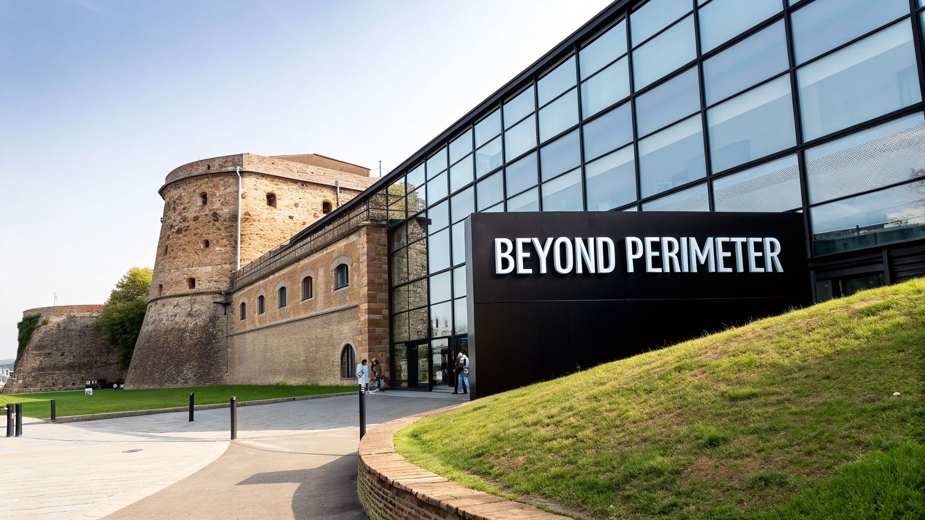 A modern glass building with a 'BEYOND PERIMETER' sign stands next to an old stone fortress.